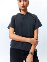 Chaleco negro lavado de algodón con capucha y gran bolsillo central. De corte oversized, holgado, suave y cómodo.