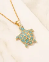 Collar de bronce dorado con cadena finita y dije en forma de tortuga con incrustaciones de piedras turquesas.