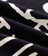 Remera negra de algodón con cuello redondo, mangas cortas y corte holgado Comfort. Cuenta con un pequeño estampado de Snoopy en el centro del pecho acompañado del texto "Snoopy".