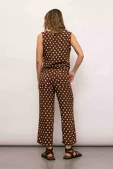 Mono marrón con lunares blancos, de corte holgado, con escote en V y lazos en la cintura.