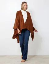 Ruana de tejido soft, color marrón óxido, de corte amplio y sin cierres, con cuello redondo.