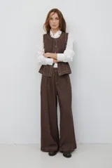 Pantalón de corte ancho y tiro alto, confeccionado en tejido con textura tipo espiga en color azul. Presenta pinzas en la cintura y costuras reforzadas.