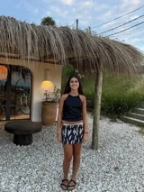 Minifalda dorada de cuero sintético, corte medio/bajo, con cortes en el delantero y pequeño tajo a un lado.