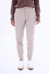 Pantalón de jogging de felpa, color beige, con cintura elástica ajustable mediante cordón y puños acanalados en los tobillos.