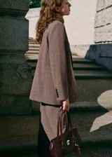 Chaqueta de corte recto estilo sastre con estampado de cuadros. Presenta cuello con solapas de muesca, hombreras, cierre frontal con botones, bolsillos laterales con solapa y bolsillo de ribete en el pecho. Incluye forro interior y abertura posterior en el bajo.
