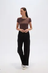 Pantalon de corte holgado y tiro alto, confeccionado en tejido de poliester con textura acanalada. Presenta cintura elástica con cordón de ajuste y diseño de pierna ancha.