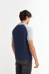 Remera tipo polo de manga corta con diseño combinado, presentando cuerpo en color azul marino y mangas y cuello en color gris. Cuenta con cierre frontal de botones.