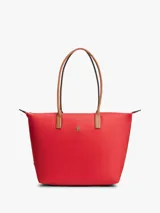 Cartera tote Tommy Hilfiger de nailon rojo, con cierre de cremallera, asas superiores de cuero sintético tostado y monograma metálico TH en la parte delantera.
