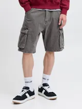 Bermuda cargo de jean de tiro alto, corte baggy fit y pernera amplia. Cuenta con múltiples bolsillos, incluyendo bolsillos cargo laterales, traseros, delanteros y para monedas, con cierre de botones y acabado stonewash efecto desgastado.