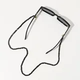 Correa para lentes negra con cuentas cúbicas y terminales doradas.