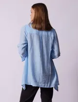 Camisa larga de rayón, con cuello clásico, cierre frontal con botones y mangas regulables con presilla. Presenta un diseño holgado con tajos laterales en el ruedo.