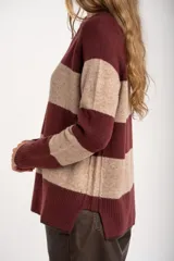 Sweater de punto con diseño de rayas horizontales anchas en color bordó y beige. Presenta cuello redondo con detalle de lurex, mangas largas y puños y ruedo acanalados.