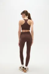 Calza deportiva de tiro alto y ajuste ceñido al cuerpo, confeccionada en tejido elástico de color bordó.