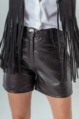Short de cuero negro con tiro alto, corte recto y cierre frontal con botón metálico.