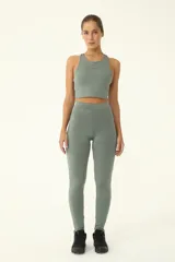 Calza deportiva de tiro alto color verde, con recortes anatómicos y cierres en los tobillos. Confeccionada en tejido de compresión con tecnología de absorción de sudor.