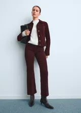 Pantalón de pana estilo flare con tiro medio, cierre de botón y cremallera, trabillas para cinturón y diseño de cinco bolsillos.