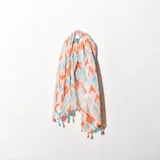 Pashmina estampada con diseño abstracto en tonos naranja, celeste y rosa, con terminaciones de flecos en color celeste.