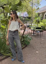 Pantalón jean azul oscuro, de corte wide leg y tiro medio. Presenta detalles de costuras diagonales en la parte superior.