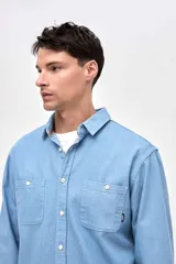 Camisa de corte regular fit confeccionada en algodón, con cuello solapa clásico, cierre frontal de botones y dos bolsillos frontales en el pecho.