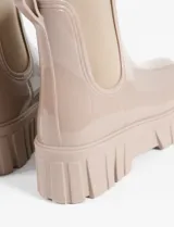 Botas de lluvia tipo chelsea con acabado brillante, suela track robusta y paneles laterales elásticos a tono.