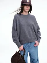 Sweater de tejido de punto en color rosa claro con motas de colores, de corte holgado, cuello redondo y mangas largas con hombros caídos.