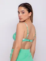 Top de bikini recto con estampado de flores y ondas en tonos verde y blanco. Tiene breteles finos regulables, se ata en la espalda y cuenta con forro y copas desmontables.