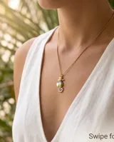 Collar de bronce con cadena fina dorada y dije colgante en forma de caballito de mar con detalles en esmalte celeste.
