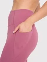 Calza deportiva color rosa viejo, tiro alto, con bolsillos laterales y banda de silicona interior en la cintura.