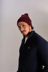 Gorro de lana tejido en punto rib, color bordó, con diseño de doblez en el borde y etiqueta pequeña lateral.