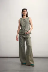 Chaleco azul de denim con cuello en V y cierre frontal con botones metálicos. Posee bolsillos delanteros y corte clásico.