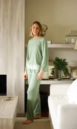 Pijama gris con textura acanalada, compuesto por una remera de manga larga con detalle de puntilla blanca en el ruedo y un pantalón recto con elástico en la cintura y detalle de puntilla blanca en los laterales.