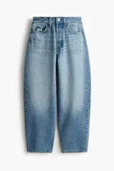 Jean tobillero de cinco bolsillos en denim de algodón rígido, con piernas de volumen curvo, tiro alto y cierre de botones.