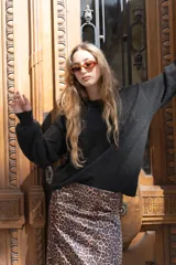 Buzo tejido color gris claro, de corte oversize y cuello redondo.