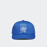 Gorro de béisbol color verde oliva con bordado frontal que incluye una flor sonriente con piernas y las letras "STANCE" rodeándola.