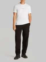 Remera blanca de algodón con cuello redondo y mangas cortas. Presenta un estampado en relieve de Calvin Klein Jeans en el pecho.
