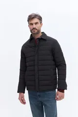 Campera puffer negra de líneas horizontales, con cuello camisero y cierre frontal oculto. Presenta un diseño minimalista con bolsillos laterales funcionales.