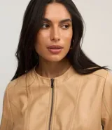 Campera básica de cuero sintético (PU) color marrón oscuro, con cuello redondo, cierre frontal y recortes decorativos. Cuenta con mangas largas y bolsillos con cierre.