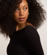 Vestido midi negro de rib con viscosa certificada, corte ajustado, escote U, manga larga, espalda abierta y pliegues.