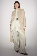 Abrigo largo de corte minimalista confeccionado en mezcla de lana, con diseño de solapas integradas, manga larga y cinturón ajustable del mismo tejido.