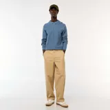 Pantalón de sarga color beige, de corte ancho y tiro alto, con cierre frontal y bolsillos laterales.