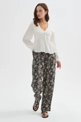Blusa blanca de viscosa, con cuello en V, detalles de frunces en el frente, botones decorativos y mangas largas holgadas.