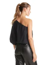 Blusa de un hombro color negro, con diseño asimétrico, una manga larga abullonada, forro interno y apliques de flores de tela en el frente.