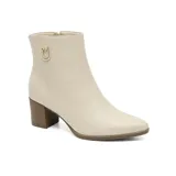 Bota corta de cuero negro con taco cuadrado y punta fina. Presenta un detalle metálico dorado con logo en el lateral superior y cierre lateral.