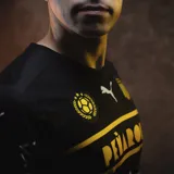 Camiseta de fútbol Puma del Club Atlético Peñarol, color negro con detalles en amarillo y blanco. Incluye logo de Puma, escudo del club, sponsor Antel y BBVA.