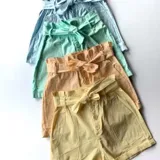 Short color amarillo pastel con cintura elastizada y detalle de botones frontales.