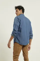 Camisa de hombre de denim azul, manga larga, con cuello buttondown y un bolsillo de parche en el pecho izquierdo.