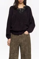 Jersey de punto en mezcla de mohair y lana, color negro con efecto jaspeado. Presenta un escote en V decorado con una aplicación de encaje negro y mangas largas con corte holgado.