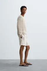 Bermuda relaxed fit confeccionada en tejido ligero de cáñamo. Presenta cintura elástica ajustable con cordón interior, bolsillos laterales y un bolsillo trasero de plastrón con solapa.