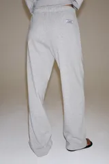 Pantalón ancho de felpa en color gris melange, con tiro medio y cintura elástica ajustable con cordón. Cuenta con bolsillos laterales ocultos en costura y diseño de pernera ancha.