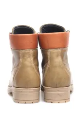 Borcego color marrón claro de cuero liso, con cordones y suela de goma.